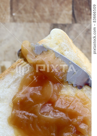 Plenty of peanut cream spread on bread Plenty of peanut cream spread on bread 83666509