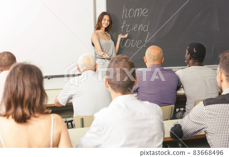 Serious female lecturer talking to students 83668496
