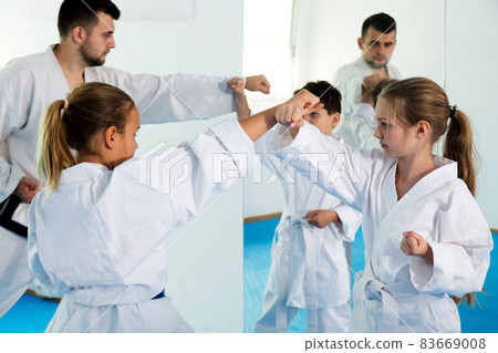 Children enjoying their trainings with coach at karate Children enjoying their trainings with coach at karate 83669008