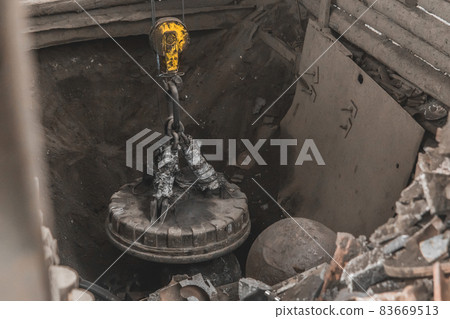Magnetic scrap crane recycles and unloads junk and old metal in a landfill Magnetic scrap crane recycles and unloads junk and old metal in a landfill 83669513