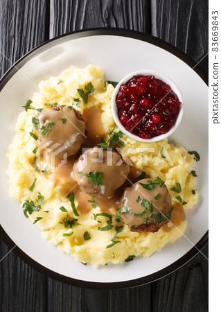 Lihapullat Traditional Finnish Meatballs with mashed potatoes and lingonberry jam close-up in a plate. vertical top view 83669843