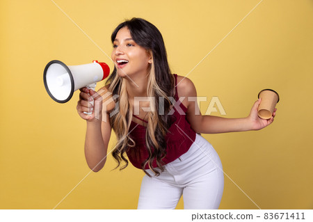 Portrait of young beuatiful girl, student in casual style clothes shouting at megaphone isolated on yellow studio backgroud. Portrait of young beuatiful girl, student in casual style clothes shouting at megaphone isolated on yellow studio backgroud. 83671411