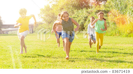 Children running on green grass 83671419