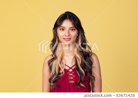 Close-up portrait of young beuatiful girl, student in bright red top isolated on yellow studio backgroud. 83671428