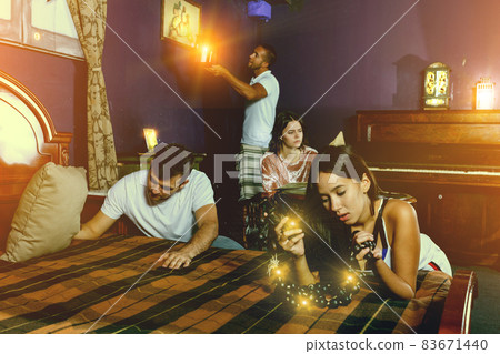 Friends looking at wooden rosary in quest room Friends looking at wooden rosary in quest room 83671440