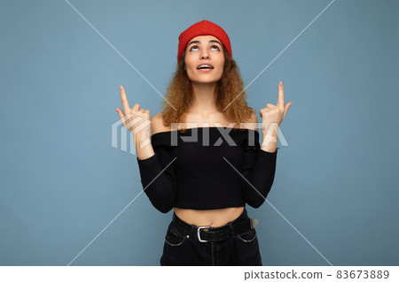 Photo of young surprised amazed attractive brunette curly woman with sincere emotions wearing black Photo of young surprised amazed attractive brunette curly woman with sincere emotions wearing black 83673889