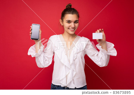 Young beautiful european stylish brunette woman wearing white blouse and fashionable hat isolated Young beautiful european stylish brunette woman wearing white blouse and fashionable hat isolated 83673895