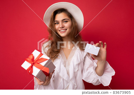 Young beautiful european stylish brunette woman wearing white blouse and fashionable hat isolated 83673905