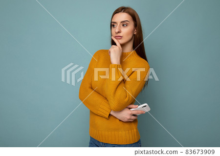 Photo of young thoughtful attractive brunette woman with sincere emotions wearing mustard pullover Photo of young thoughtful attractive brunette woman with sincere emotions wearing mustard pullover 83673909