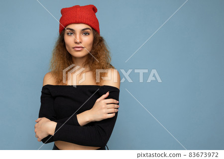 Photo of beautiful self-confident young brunette curly woman isolated over blue background wall 83673972