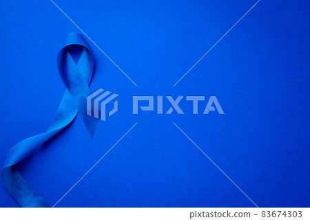 Men cancer. Awareness of men health in November with blue prostate cancer ribbon isolated on deep blue background. Adrenocortical carcinoma concept. 83674303
