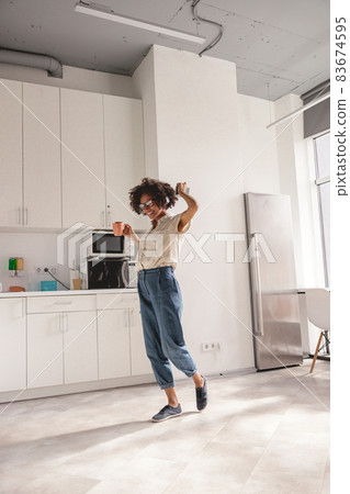 Happy young lady in glasses enjoying the music Happy young lady in glasses enjoying the music 83674595