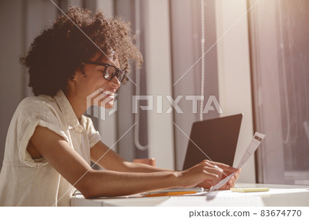 Smiling Afro American woman holding paper in the office Smiling Afro American woman holding paper in the office 83674770