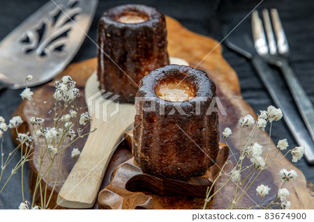 De Bordeaux Recipe is a small pastry with rum and vanilla on a wooden plate. De Bordeaux Recipe is a small pastry with rum and vanilla on a wooden plate. 83674900