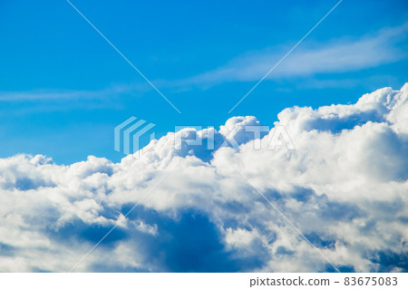 Pure fluffy white clouds on a blue sky. The view from the window of the plane. Background for design. Pure fluffy white clouds on a blue sky. The view from the window of the plane. Background for design. 83675083