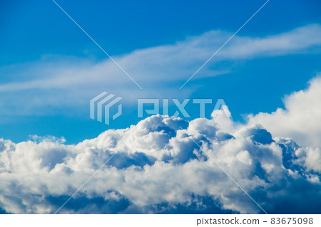 White fluffy cumulus clouds against a clear blue sky. A symbol of dreams and freedom. Background for design. 83675098