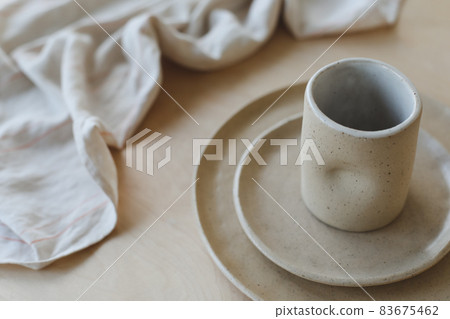 Beige ceramic plate on a wooden table top view. minimalist handmade ceramic tableware and pottery. Beige ceramic plate on a wooden table top view. minimalist handmade ceramic tableware and pottery. 83675462