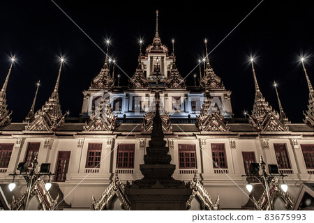Golden shining Loha Prasat (Metal Castle) lit up at night, a pyramid shaped Buddhist temple from 1846 for meditation in Wat Ratchanatdaram, Here It is the most tourist destination landmark in Phra 83675993