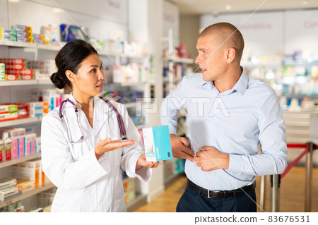 Female pharmacist consulting client in drugstore Female pharmacist consulting client in drugstore 83676531