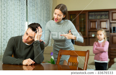 Wife scolds her husband in the presence of a child Wife scolds her husband in the presence of a child 83676533