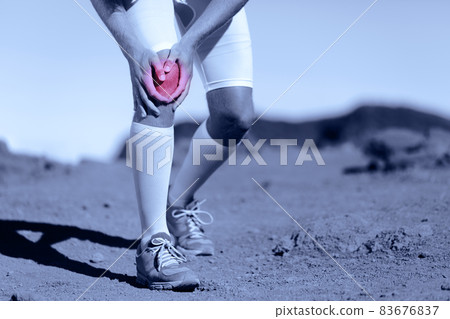 Knee pain athlete sports injury runner man running on trail race with sport health problem holding painful leg. ACL ligament tear is one of the most common knee ligament injuries. 83676837