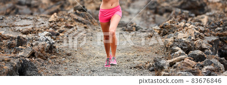 Trail running woman athlete run race on path in volcanic rocks panorama banner background. Sport fitness athlete lower body crop of legs and running shoes. Trail running woman athlete run race on path in volcanic rocks panorama banner background. Sport fitness athlete lower body crop of legs and running shoes. 83676846