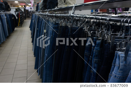 Jeans in the mall hang on hangers. Large selection of denim clothing Jeans in the mall hang on hangers. Large selection of denim clothing 83677009