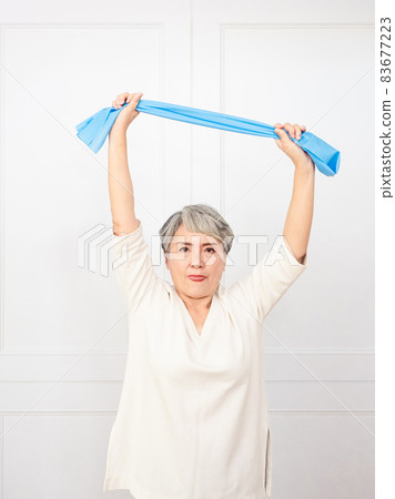 Senior asian woman doing exercises with resistance band at home. Senior asian woman doing exercises with resistance band at home. 83677223