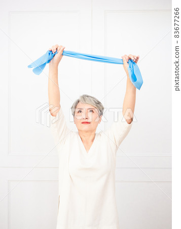 Senior asian woman doing exercises with resistance band at home. Senior asian woman doing exercises with resistance band at home. 83677266