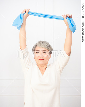 Senior asian woman doing exercises with resistance band at home. Senior asian woman doing exercises with resistance band at home. 83677268
