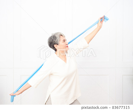 Senior asian woman doing exercises with resistance band at home. Senior asian woman doing exercises with resistance band at home. 83677315