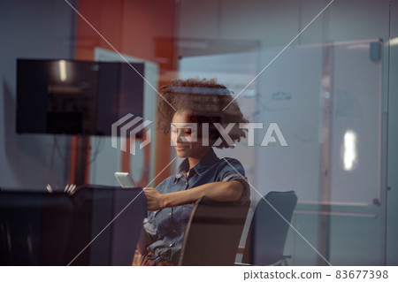 Happy young lady holding mobile phone in the office 83677398