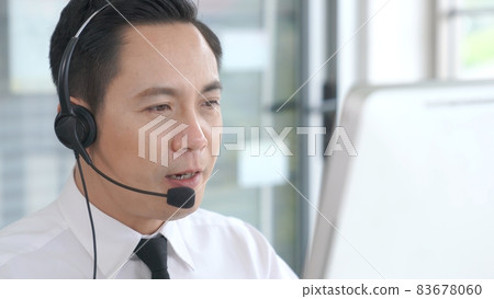 Businessman wearing headset working actively in office 83678060