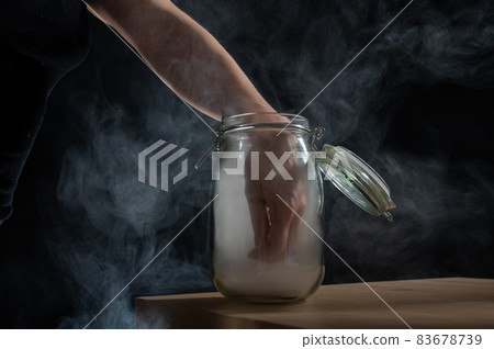 Woman takes out fog from a glass jar. Woman takes out fog from a glass jar. 83678739