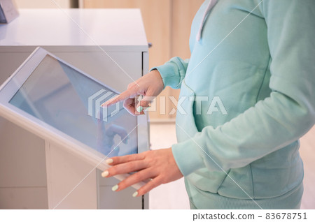 Faceless woman touching the screen of a self-service device in a store. Device store navigator. Self purchase. Faceless woman touching the screen of a self-service device in a store. Device store navigator. Self purchase. 83678751