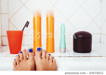 woman legs in bathroom with lot of stylish stuff for care, pedicure creative design, hygiene spa mani pedi concept woman legs in bathroom with lot of stylish stuff for care, pedicure creative design, hygiene spa mani pedi concept 83678831
