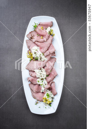 Traditional lunch meat with sliced cold cuts roast beef and remoulade 83678947