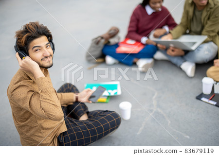 Indian man sit on asphalt and look at camera 83679119