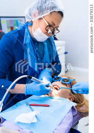 kid with oral dilator at dentist's appointment. treatment of teeth 83679313