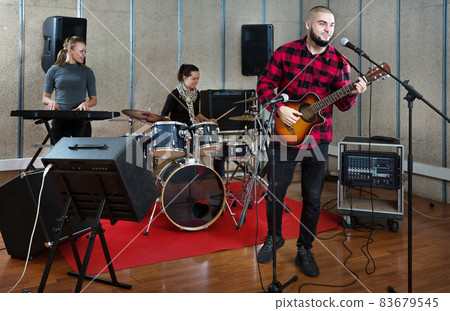 Bearded guy soloist playing guitar in studio Bearded guy soloist playing guitar in studio 83679545