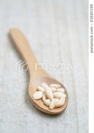 shelled pine nuts in spoon on the wooden background with copy space shelled pine nuts in spoon on the wooden background with copy space 83680199
