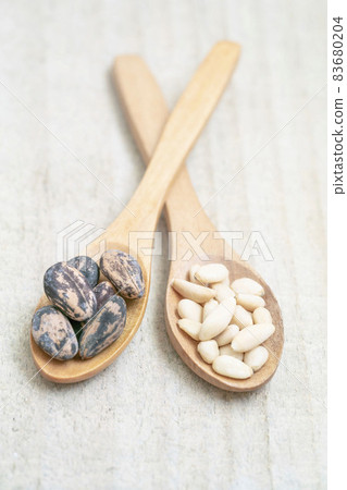shelled and whole pine nuts in spoon on the wooden background with copy space shelled and whole pine nuts in spoon on the wooden background with copy space 83680204