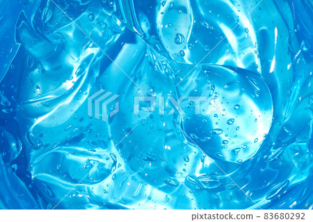 Cosmetic gel or beauty jelly serum texture background. Blue transparent skin care collagen product backdrop. Antibacterial sanitizer or liquid water moisture toner smudged smear close up photo 83680292
