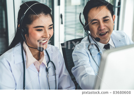 Doctor team wearing headset talking actively on video call in hospital clinic Doctor team wearing headset talking actively on video call in hospital clinic 83680608