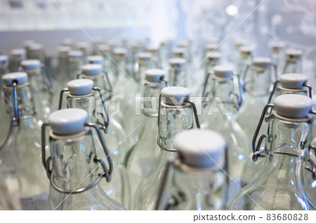 A closeup of the neck of a bottle. Group of empty bottles with plastic caps in a store on the counter. 83680828
