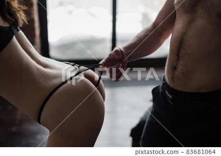 Close-up of unrecognizable man passionately pressed against the back of a woman in panties. cropped photo of a pair of lovers in foreplay. 83681064