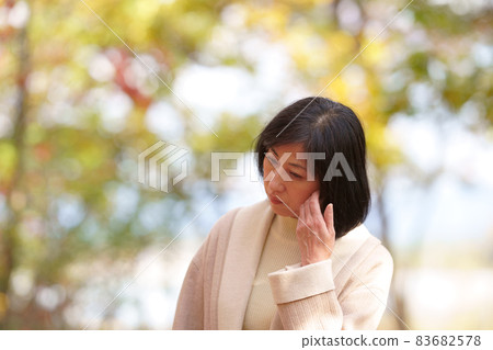 A lonely middle-aged woman in an autumn park 83682578