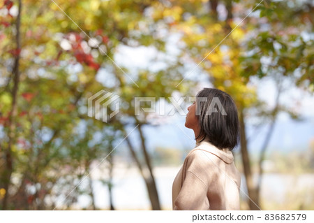 A lonely middle-aged woman in an autumn park without a face 83682579