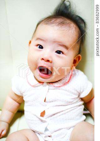 A baby in a good mood with a surprised expression A baby in a good mood with a surprised expression 83682999