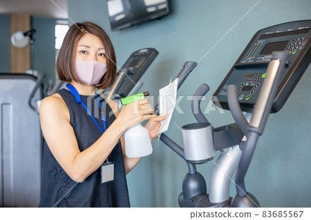 A woman who disinfects a gym with alcohol A woman who disinfects a gym with alcohol 83685567